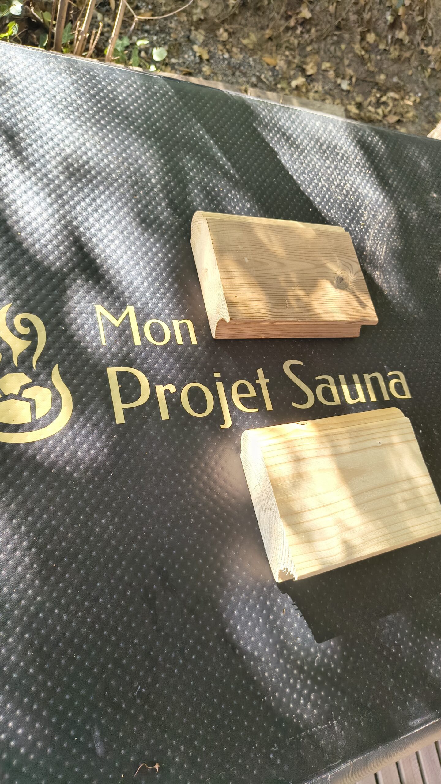 Échantillons d'épicéa et de thermowood côte à côte au showroom sauna de Haute-Garonne